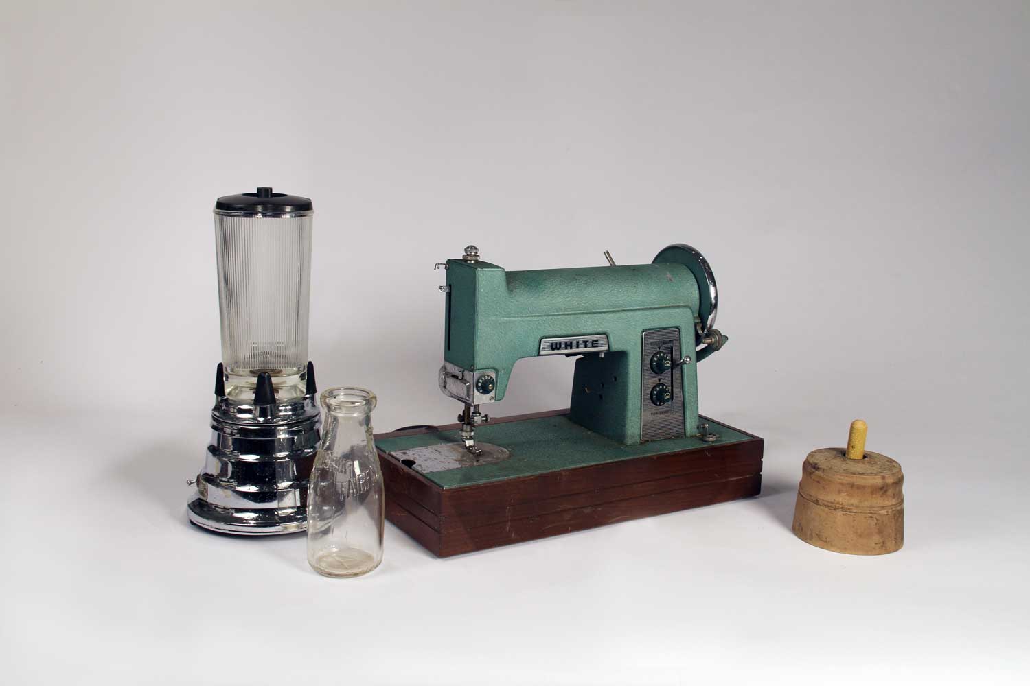 Waring Blender, 1947; Milk bottle, mid-20th century; Sewing Machine, late 19th century; Butter mold, 1920s. Photo by Museum staff.