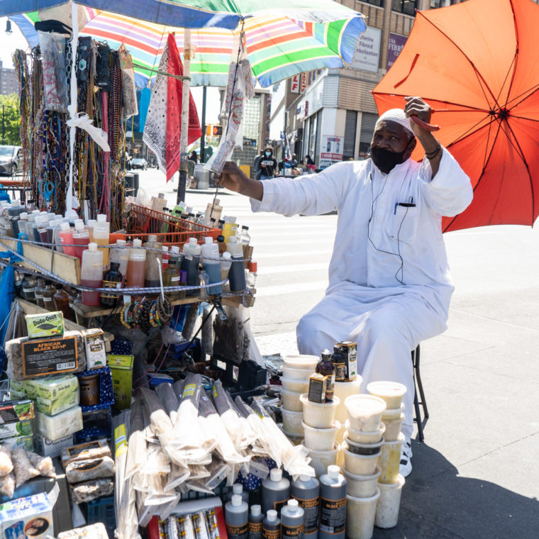 May 25, 2020: Street vendor selling African and West Indian imports, Third Avenue at East 149th Street, Bronx, New York. © Camilo José Vergara 