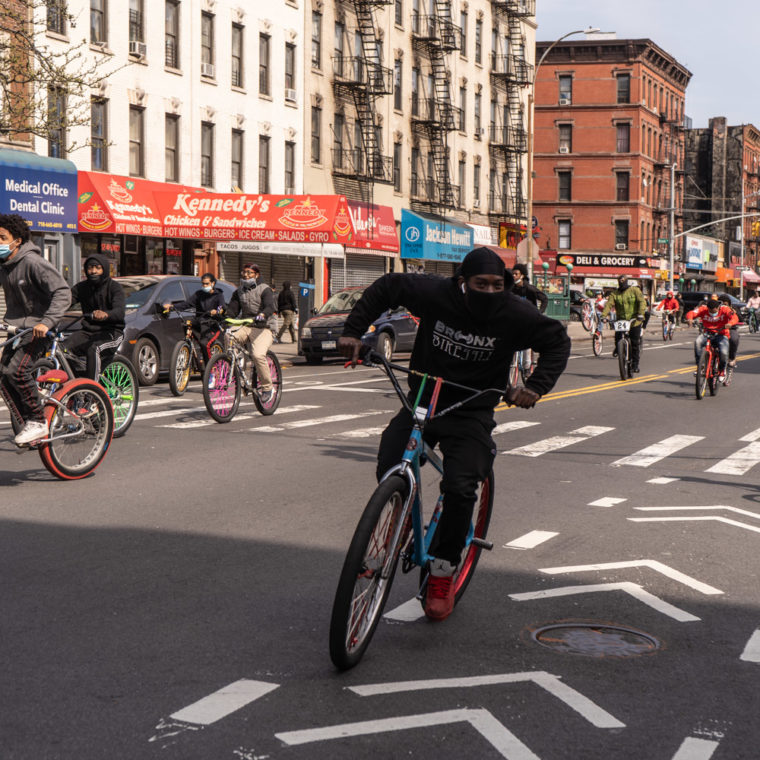 April 19, 2020: Teenagers wearing masks riding their bikes along East 138th Street and Brook Avenue in the Bronx, New York. © Camilo José Vergara 