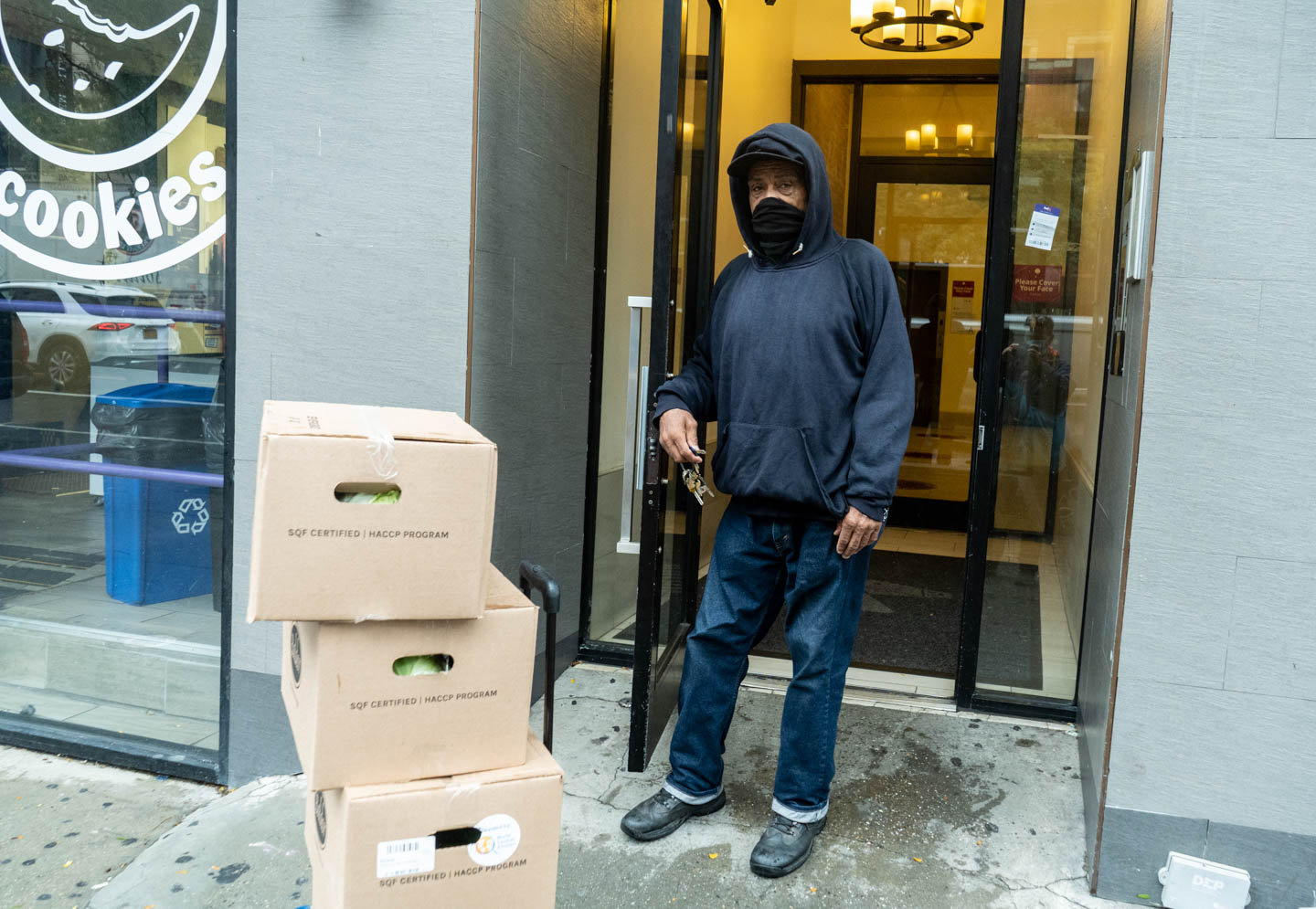 October 13, 2020: Joe, a retired sanitation worker, carrying boxes of free produce from Red Rooster Restaurant. He brought the boxes for elderly and sick residents of his building who were unable to get it themselves. 17 West 125th Street, Harlem, New York, New York. © Camilo José Vergara