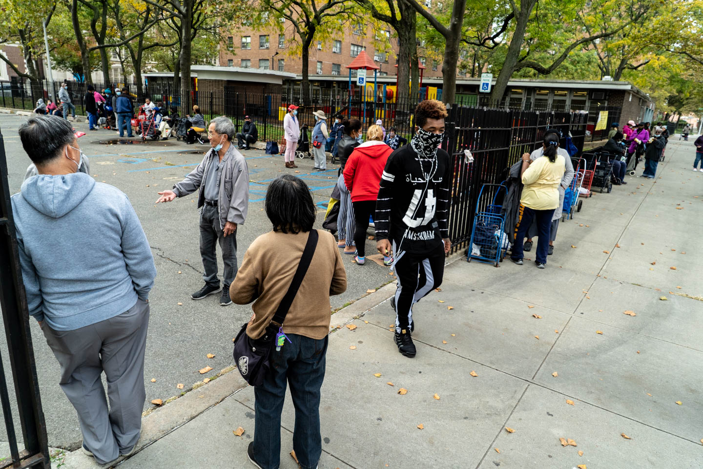 October 21, 2020: Waiting for the 4:00 pm food truck. Public housing parking lot, Powell Street at Sutter Avenue, Brooklyn, New York. © Camilo José Vergara
