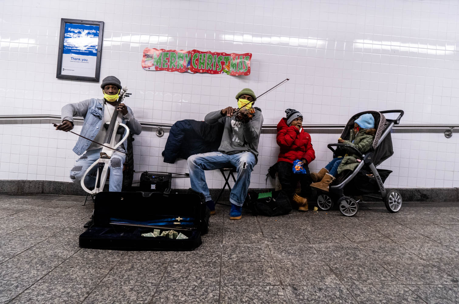 December 23, 2020: Merry Christmas. Musicians and children, Penn Station, New York, New York. © Camilo José Vergara