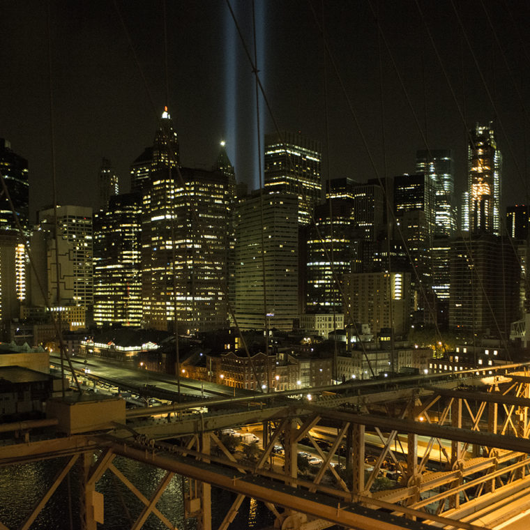 View west from the Brooklyn Bridge capturing the annual September 11 “Tribute in Light,” a commemorative art installation that recreates the shapes of the towers, Brooklyn, New York; 2017. 